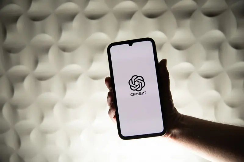 A person holds a telephone displaying OpenAI s ChatGPT artificial intelligence logo in front of a white lit background in Kerlouan in Brittany in France on February 26 2025. (Photo by Vincent Feuray / Hans Lucas / Hans Lucas via AFP) (Photo by VINCENT FEURAY/Hans Lucas/AFP via Getty Images)