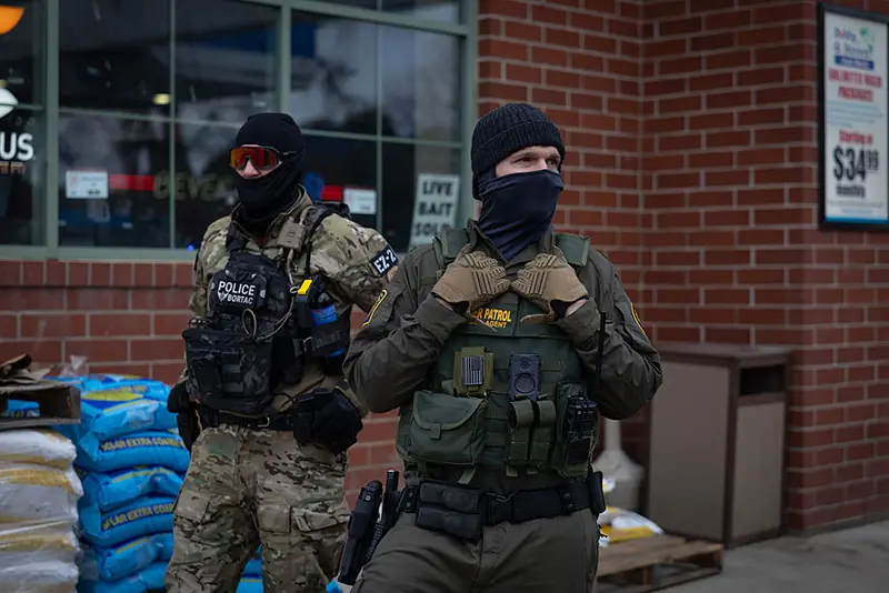 U.S. Border Patrol agents stand watch during a stop at a gas station on January 13, 2026 in Minneapolis, Minnesota. (Photo by Scott Olson/Getty Images)